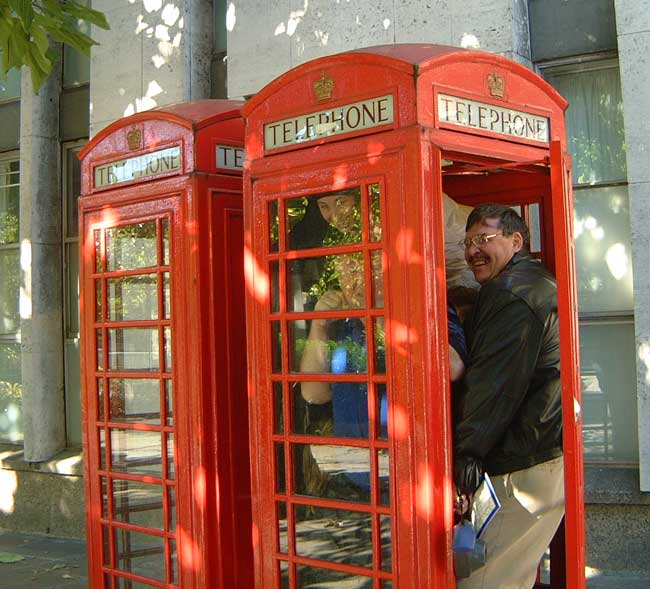 People getting into a phone box on the streets of London.